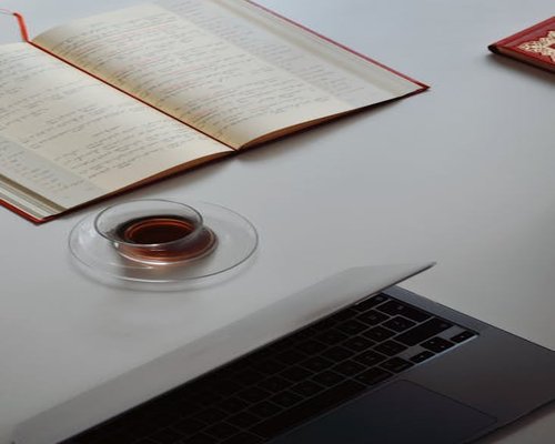 A desk setup with a cup of Kenyan tea and a notebook